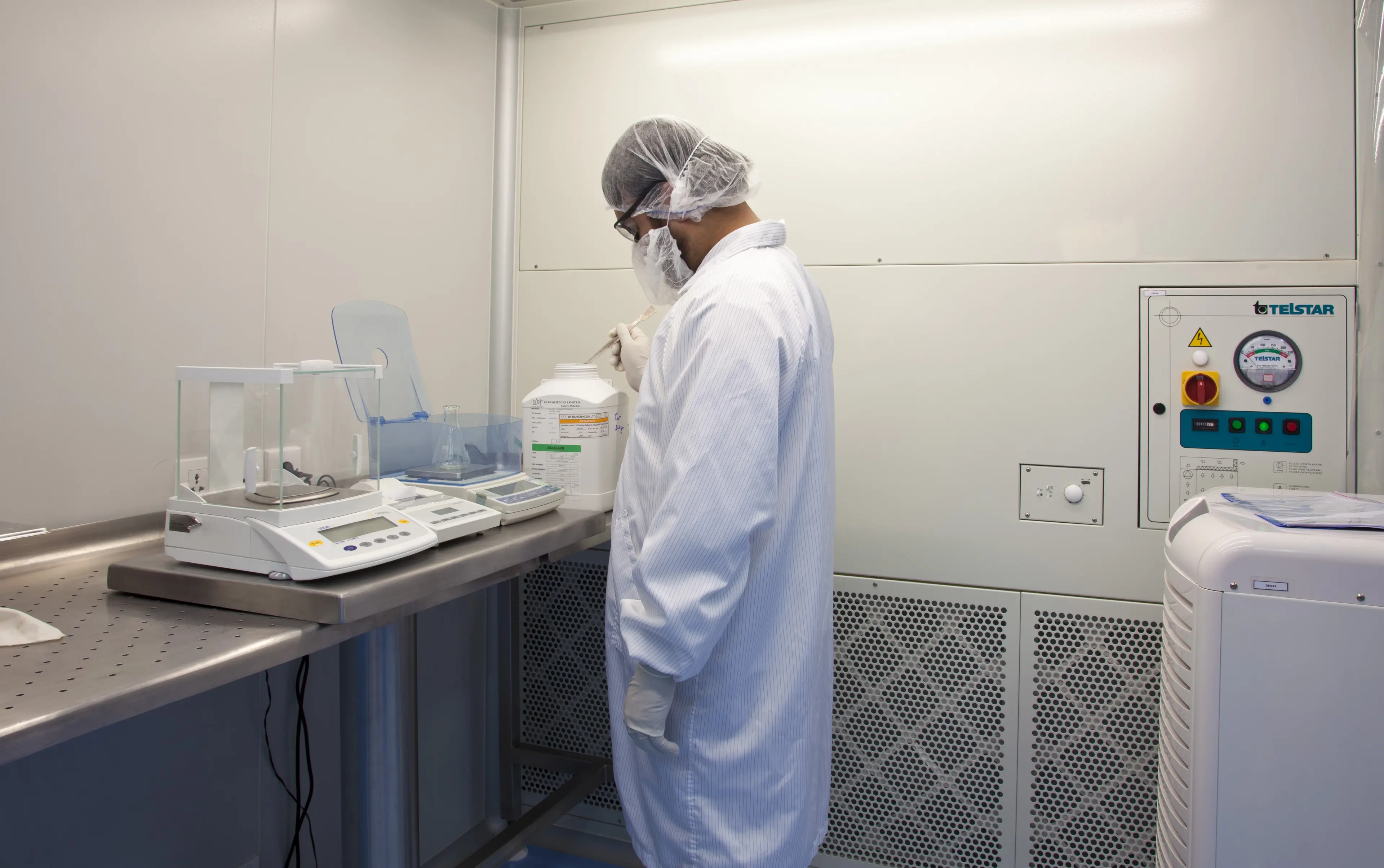 Scientist weighing materials in a controlled laboratory